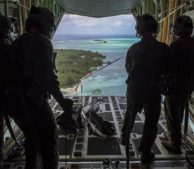 Loadmasters with the 36th Airlift Squadron out of Yokota AB, Japan, watch as humanitarian assistance bundles they just airdropped parachute down to those in need during Operation Christmas Drop 2019, at Nomwin, Federated States of Micronesia, Dec. 13, 2019. Air Force photo by SrA. Matthew Gilmore.