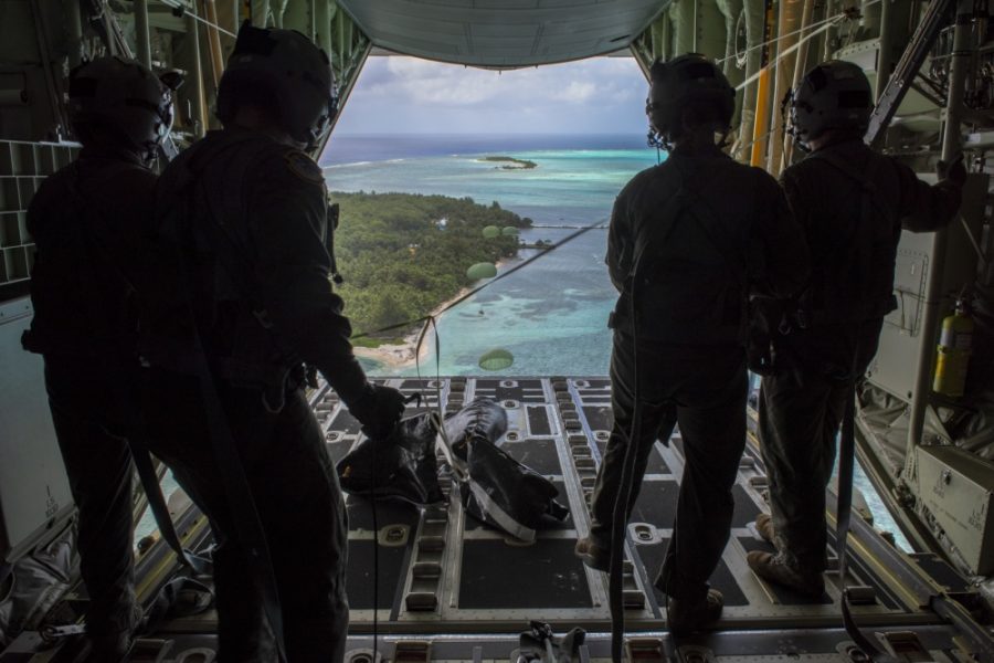 Loadmasters with the 36th Airlift Squadron out of Yokota AB, Japan, watch as humanitarian assistance bundles they just airdropped parachute down to those in need during Operation Christmas Drop 2019, at Nomwin, Federated States of Micronesia, Dec. 13, 2019. Air Force photo by SrA. Matthew Gilmore.