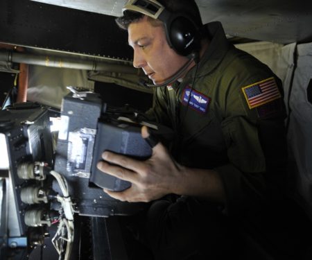 MSgt. David Dines reloads the film magazine on a panoramic camera Jan. 16, 2010, while flying over Haiti on an OC-135B observation aircraft. Air Force photo by SrA. Perry Aston.