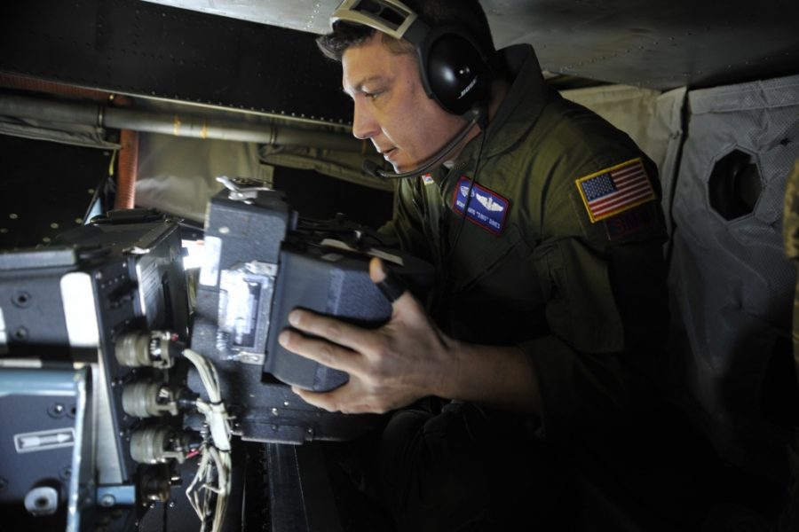 MSgt. David Dines reloads the film magazine on a panoramic camera Jan. 16, 2010, while flying over Haiti on an OC-135B observation aircraft. Air Force photo by SrA. Perry Aston.