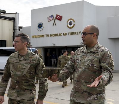 Maj. Gen. John Klein, U.S. Air Force Expeditionary Center commander, left, speaks with Senior Master Sgt. Adrian E. Holguin, 728th Air Mobility Squadron aerial port superintendent, at Incirlik Air Base, Turkey, Feb. 25, 2023.